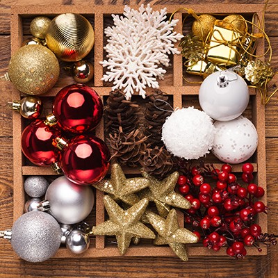 Xmas decorations. Christmas shiny baubles inside of wooden box closeup. Winter holidays concept.